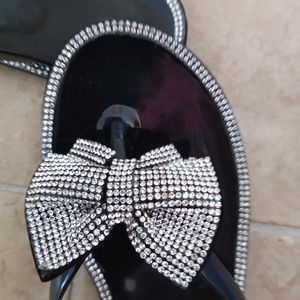 Black flip flops with clear rhinestones with a bow